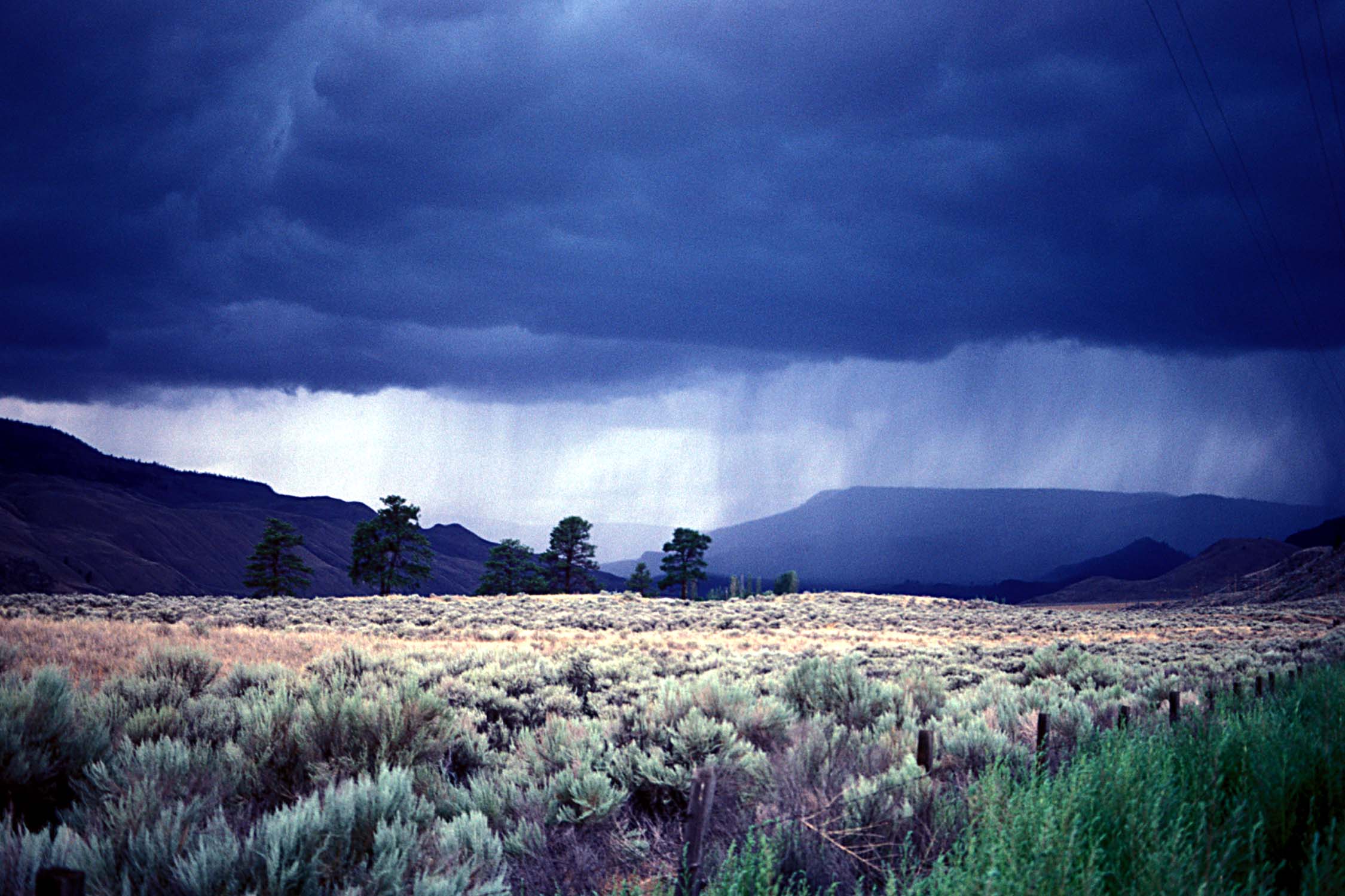 A dark raincloud over a valley